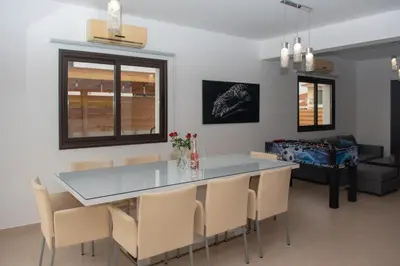 a dining room with a glass table and chairs at Villa Fortuna in Ayia Napa