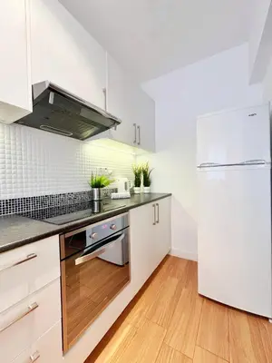 a kitchen with white cabinets and a refrigerator at Central 2 Bedroom Apt Terrace and Pool in Ayia Napa