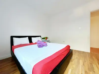 a bedroom with a large bed with red and white sheets at Central 2 Bedroom Apt Terrace and Pool in Ayia Napa