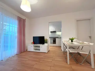 a living room with a table and a television at Central 2 Bedroom Apt Terrace and Pool in Ayia Napa