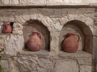 three clay vases sitting on a stone wall at Evanthia's Stone House in Koilani