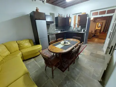 a living room with a table and a yellow couch at Evanthia's Stone House in Koilani
