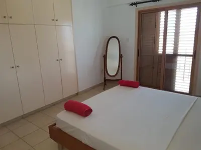 a bedroom with a large white bed and a mirror at Sunrise Villa in Ayia Napa