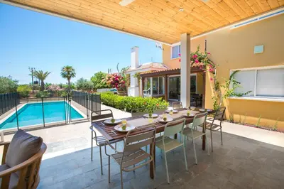 a patio with a table and chairs and a pool at Ayia Napa Villa Danae in Ayia Napa