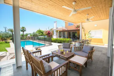 a patio with a table and chairs and a pool at Ayia Napa Villa Danae in Ayia Napa