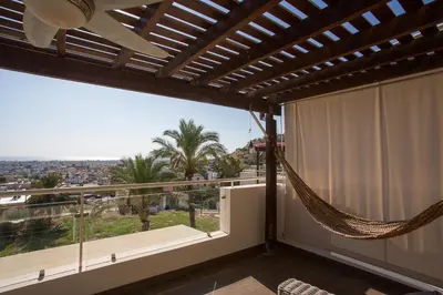 a balcony with a hammock and a view of the city at Penthouse Duplex overlooking the Mediterranean in Larnaka