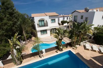 a house with a swimming pool in front of a house at Villa Anatoli - Cape Greco in Protaras
