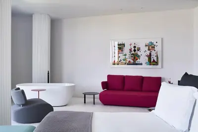 a living room with a red couch and a tub at MAP Boutique Hotel in Nicosia