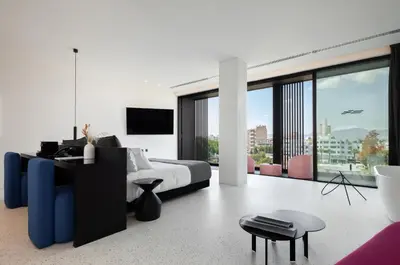 a white bedroom with a bed and a tv at MAP Boutique Hotel in Nicosia