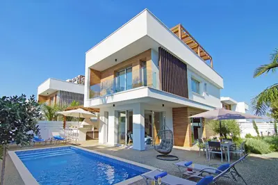 a house with a swimming pool in front of it at Villa Lily in Protaras
