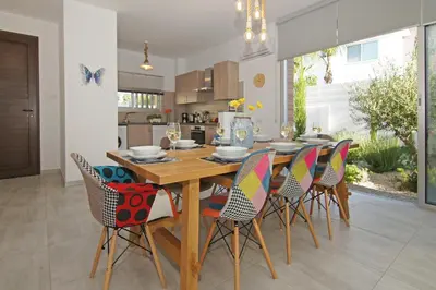 a kitchen and dining room with a wooden table and chairs at Villa Lily in Protaras