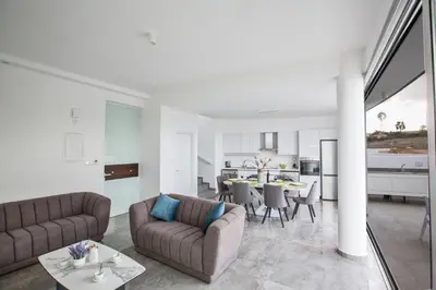 a living room with two couches and a table at Olivine Pearl Villas in Protaras