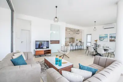 a living room with two couches and a dining room at Olivine Pearl Villas in Protaras