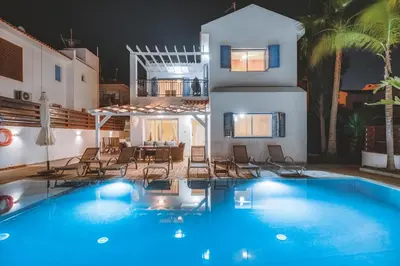 a villa with a swimming pool at night at Amphitrite Villa in Paralimni