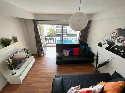 a living room with a couch and a tv at Napa Blue Apartment, XXL Pool,in Hearth of Ayia Napa in Ayia Napa