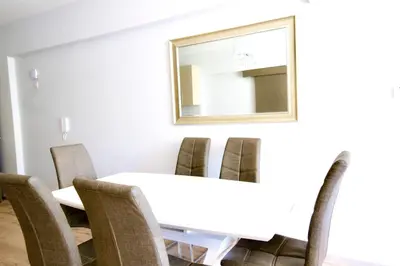 a dining room table with chairs and a mirror at Galatex Sea Breeze in Limassol