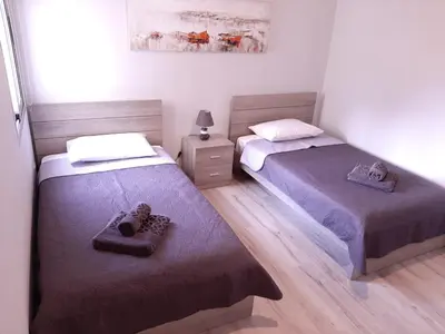 a bedroom with two beds and a night stand at Galatex Sea Breeze in Limassol