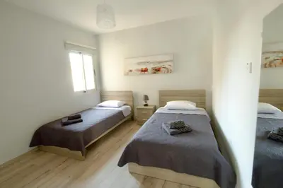 a bedroom with two beds and a window at Galatex Sea Breeze in Limassol