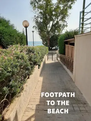 a walkway to the beach with the words footprints to the beach at Galatex Sea Breeze in Limassol