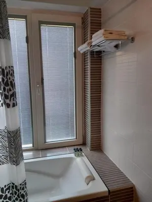 a bathroom with a bath tub and a window at Saint John Sia house in Nicosia