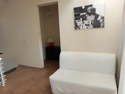 a white couch in a living room with a picture on the wall at Saint John Sia house in Nicosia