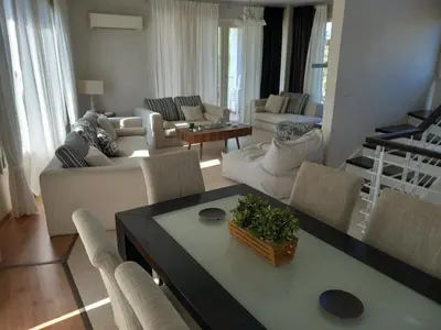 a living room with a couch and a table and chairs at Saint John Sia house in Nicosia