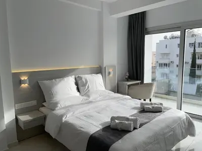 a bedroom with a large white bed and a window at La Veranda Hotel in Larnaka