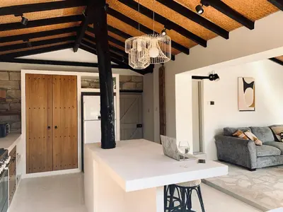 a kitchen and living room with a ceiling with beams at The Goathouse in Larnaka