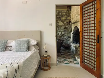 a bedroom with a bed and a stone fireplace at The Goathouse in Larnaka