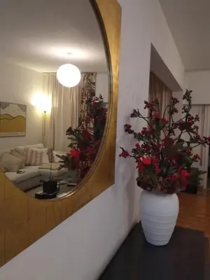 a living room with a mirror and a vase with flowers at Seaside Spacious Apartment with Sea View in Limassol