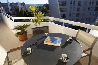a table and chairs on a balcony with a book at Seaside Spacious Apartment with Sea View in Limassol