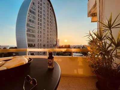 a bottle of beer sitting on a table on a balcony at Seaside Spacious Apartment with Sea View in Limassol