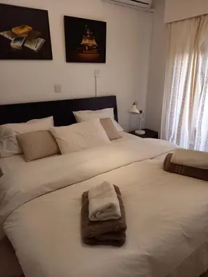 a bedroom with two beds with towels on them at Seaside Spacious Apartment with Sea View in Limassol