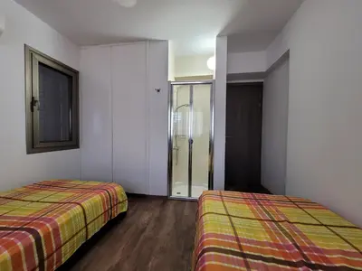 a bedroom with two beds and a sliding glass door at Poros 2 Villa in Protaras