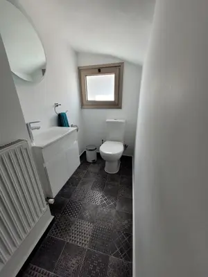 a bathroom with a white toilet and a sink at Poros 2 Villa in Protaras