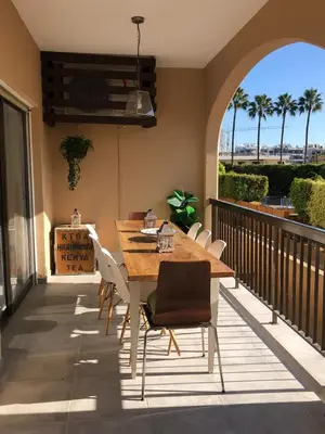 a wooden table and chairs on a balcony with a view at Sun city apartment in Limassol