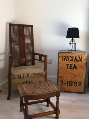 a chair and a table with a lamp and a box at Sun city apartment in Limassol