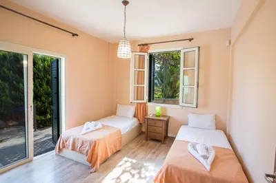 two beds in a room with two windows at Villa Joy in Protaras