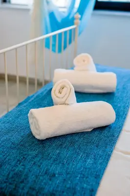 two white towels sitting on a blue rug at Krasas Beach Apts in Larnaka