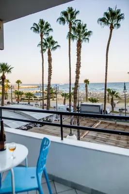 a view of the beach from a restaurant with palm trees at Krasas Beach Apts in Larnaka