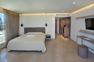 a bedroom with a bed and a flat screen tv at Nelia Beach Hotel & Spa in Ayia Napa