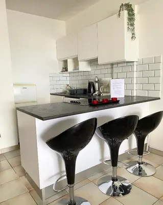 a kitchen with a counter with two bar stools at Krasas Beach Apartments in Larnaka
