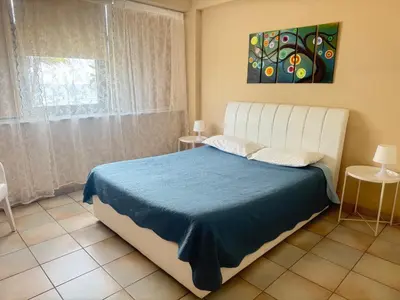 a bedroom with a bed and a painting on the wall at Krasas Beach Apartments in Larnaka