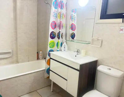 a bathroom with a sink and a toilet and a tub at Krasas Beach Apartments in Larnaka