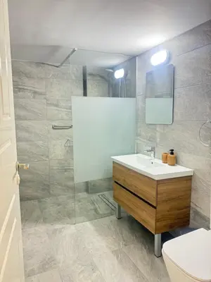 a bathroom with a sink and a shower with a mirror at Krasas Beach Apartments in Larnaka