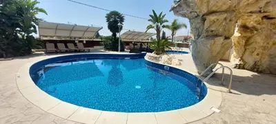 a large pool with blue water in a resort at Pyla Palms A1 204 in Pyla