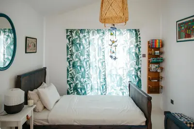 a bedroom with a bed and a window with a curtain at Island Home Seaside Villa in Paralimni