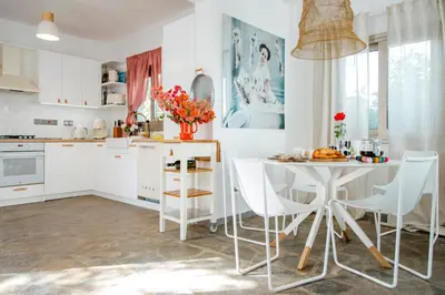 a kitchen with white cabinets and a table and chairs at Island Home Seaside Villa in Paralimni