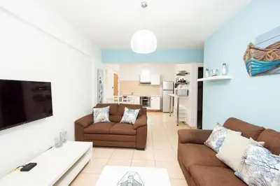 a living room with two couches and a tv at Olympia flat 201 in Larnaka