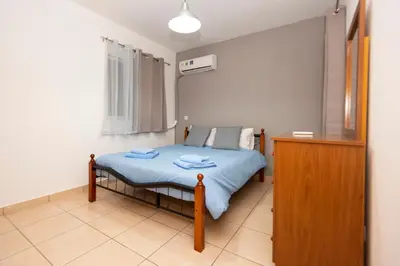 a small bedroom with a bed with blue sheets at Olympia flat 201 in Larnaka